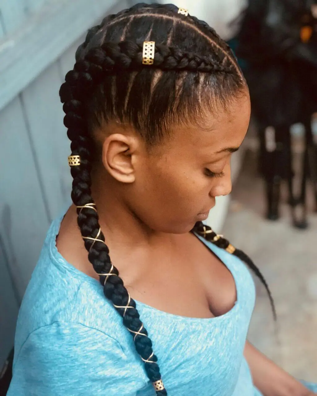 A woman with braids and a blue shirt
