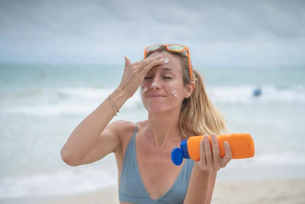 A woman on the beach with sunscreen on her face
