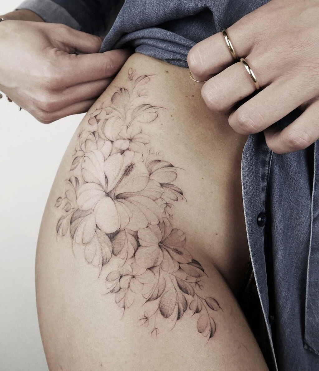 A woman with a flower tattoo on her thigh
