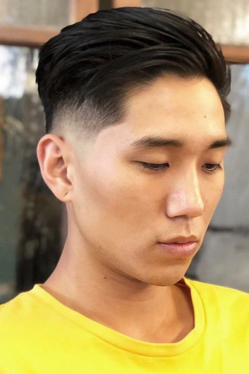 A men with yellow shirt and two block haircut
