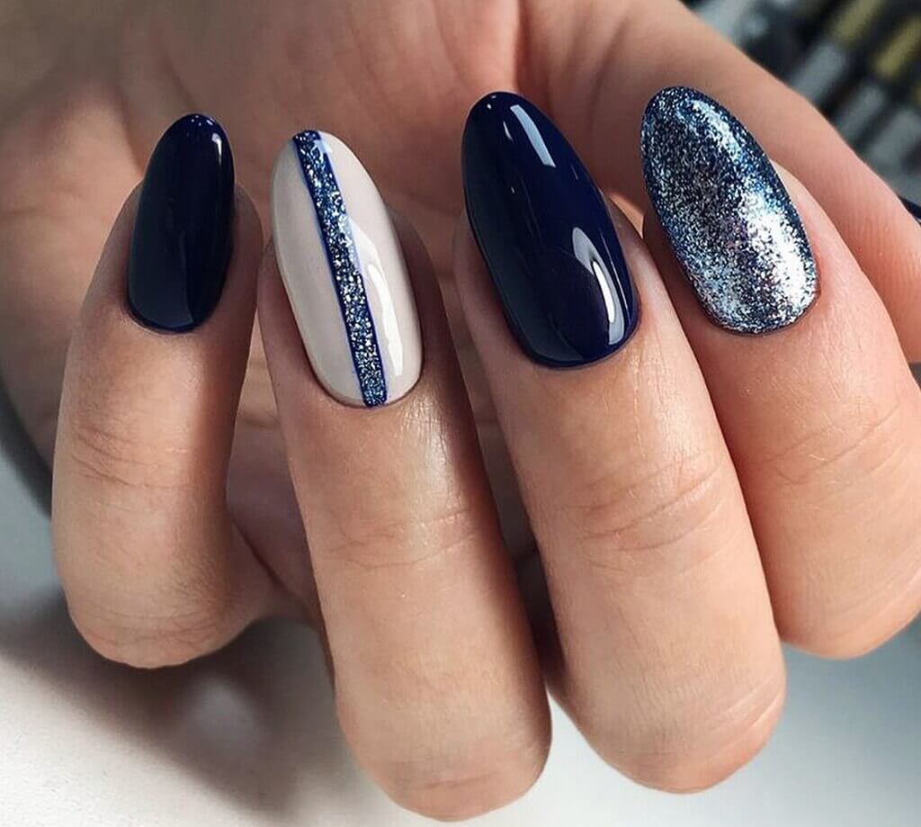 A woman's hand with a blue and white manicure
