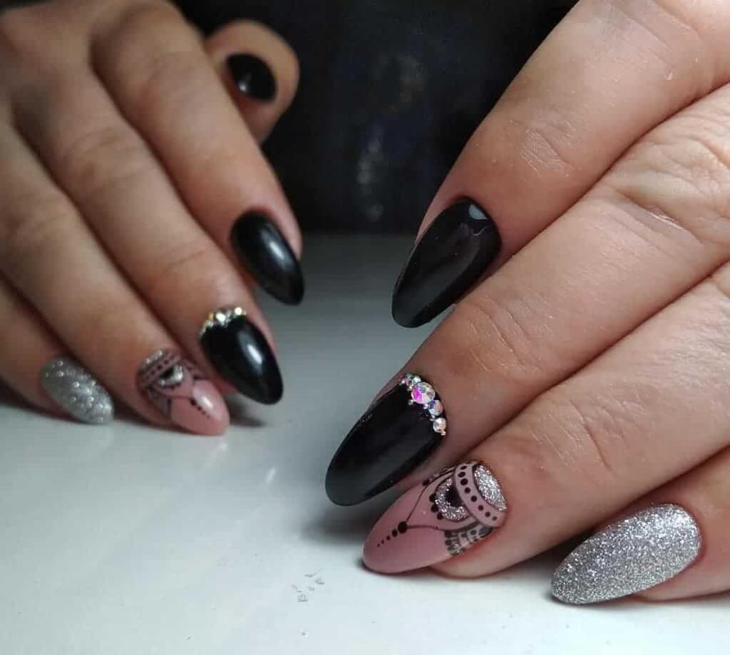 A woman's hands with black and silver nail polish
