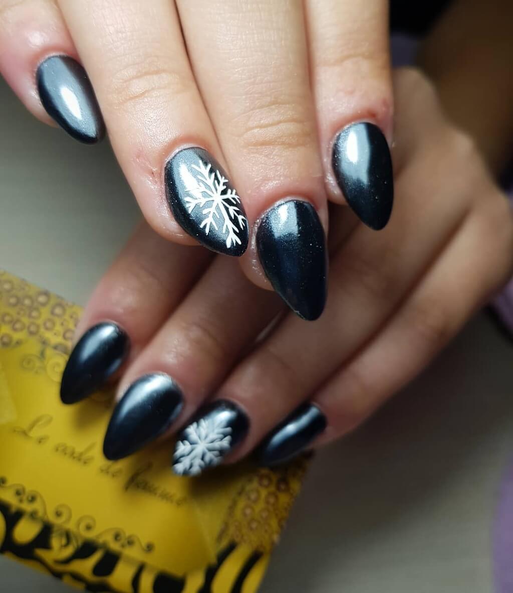 A woman's nails with a snowflake design
