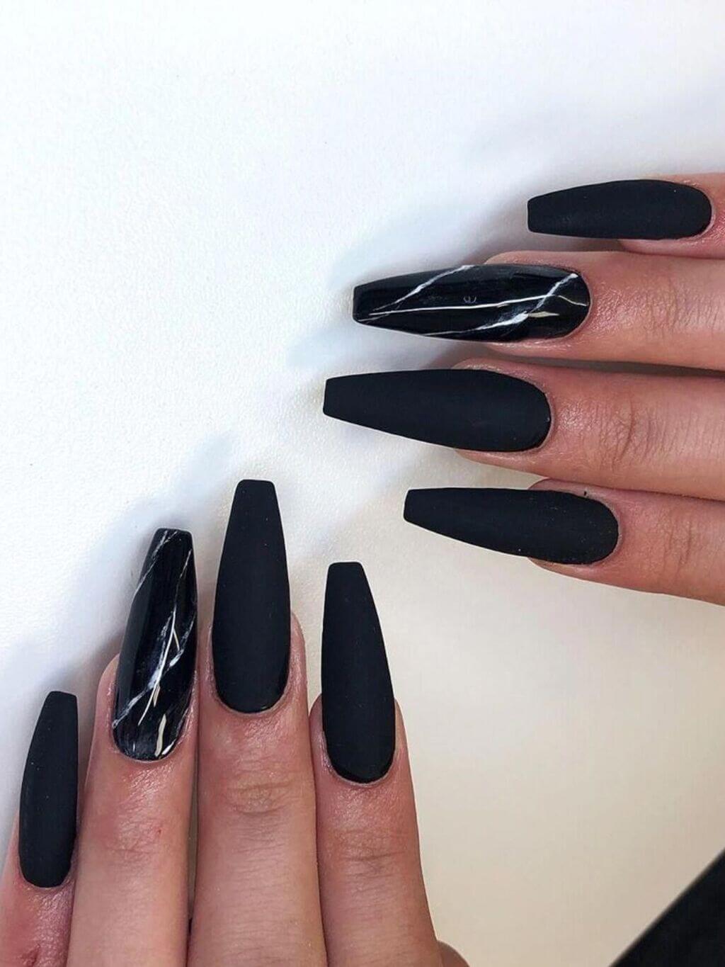 A woman's hand with long black nails
