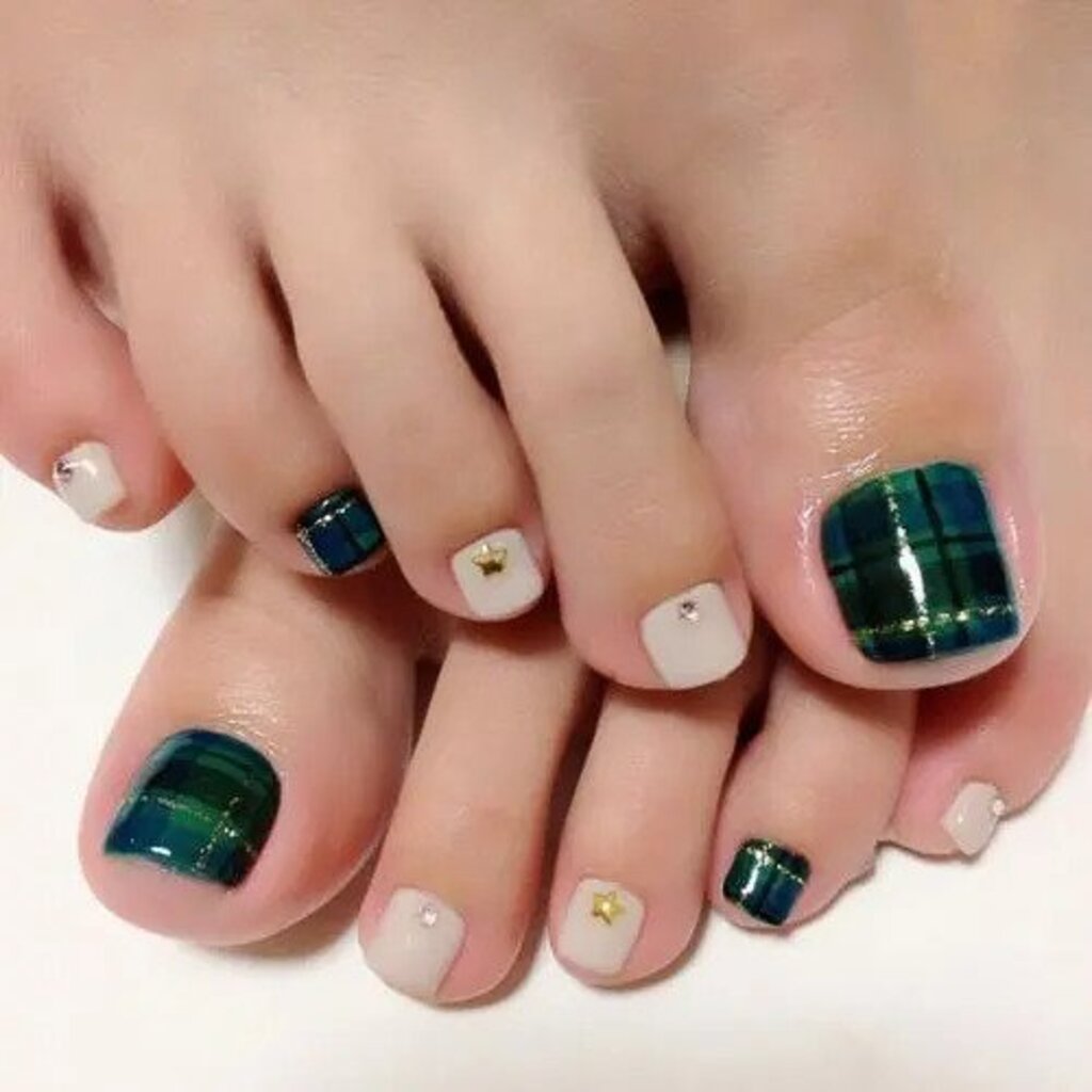 A pair of feet with green and white designs on them
