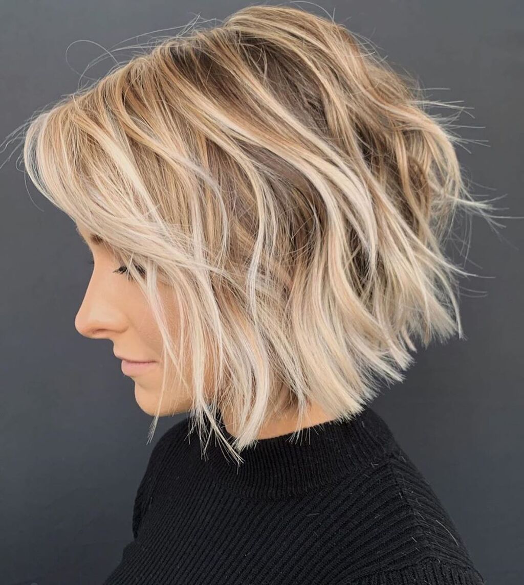 A woman with blonde shoulder length funky short stacked bob cut
