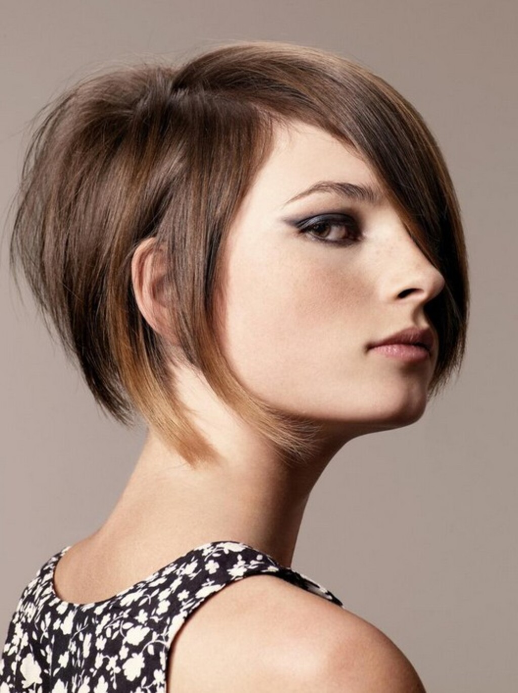 A woman with funky short stacked bob hair style and wear black and with floral dress