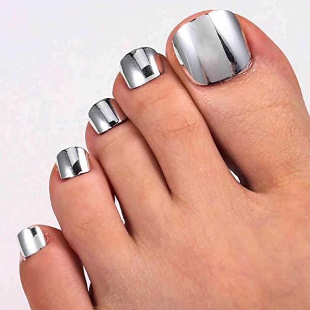 A woman's foot with silver nail polish on it
