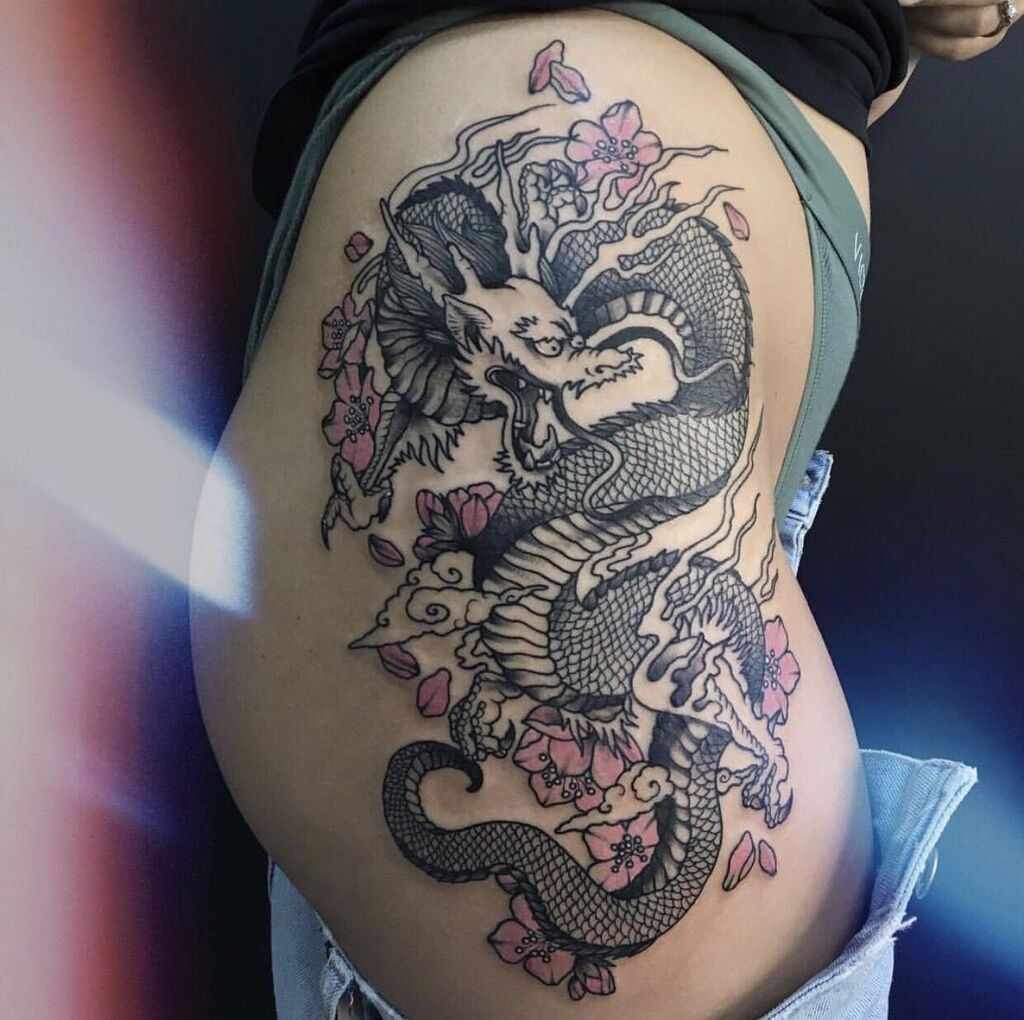 A woman with a dragon tattoo on her thighs