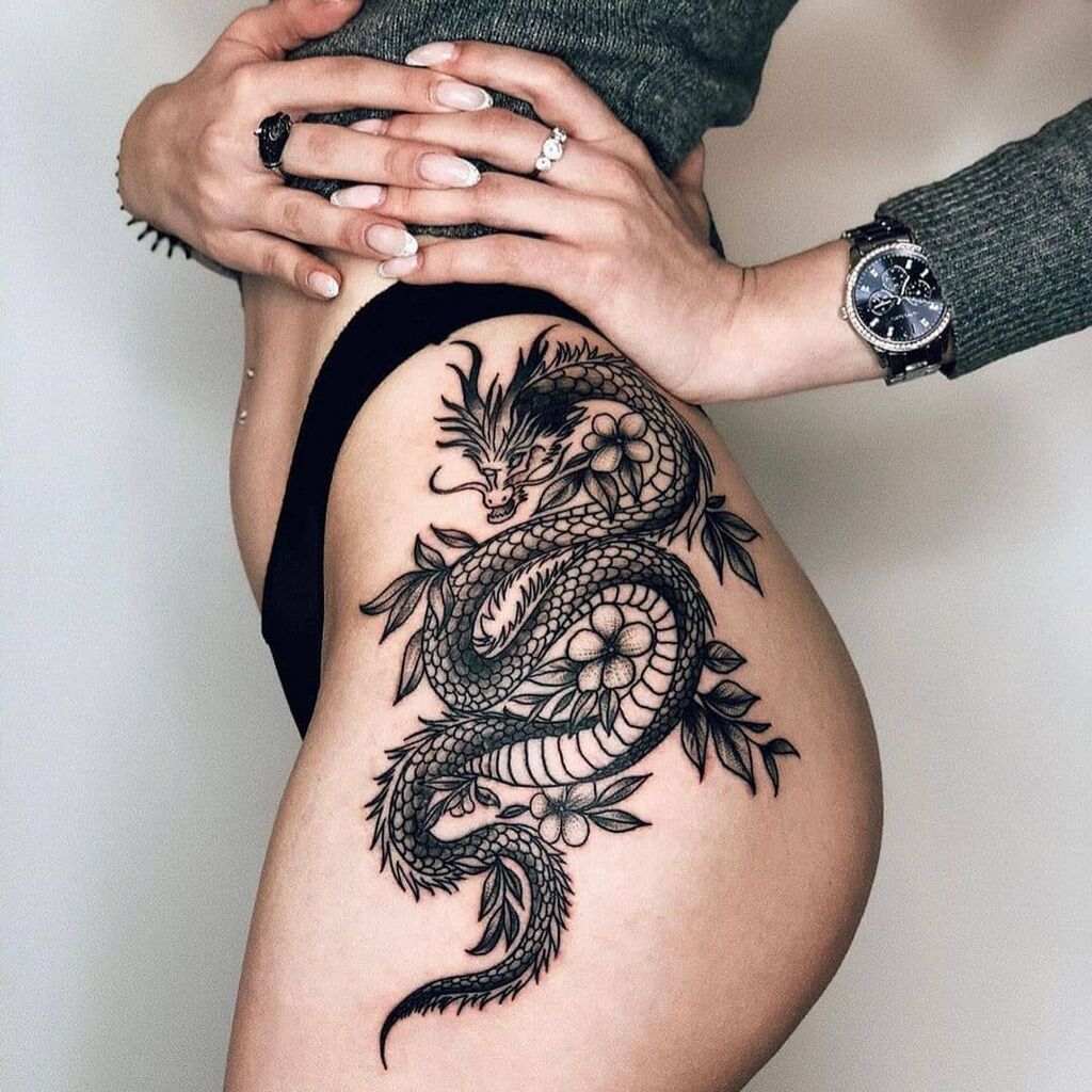 A woman with a Black dragon tattoo on her thigh
