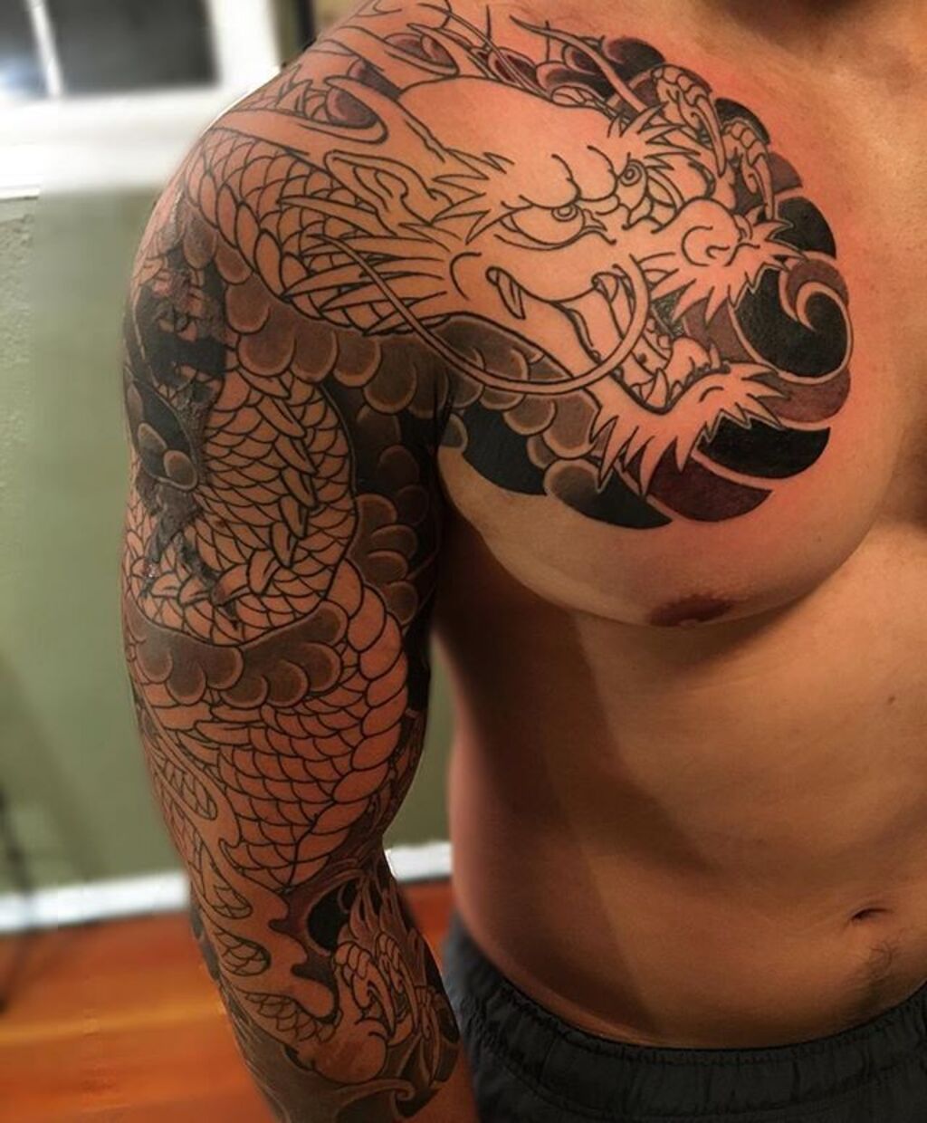 A man with  japanese dragon tattoo on his ches