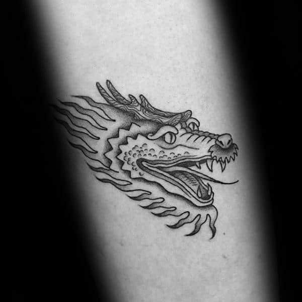 A black and white  tattoo of a dragon
