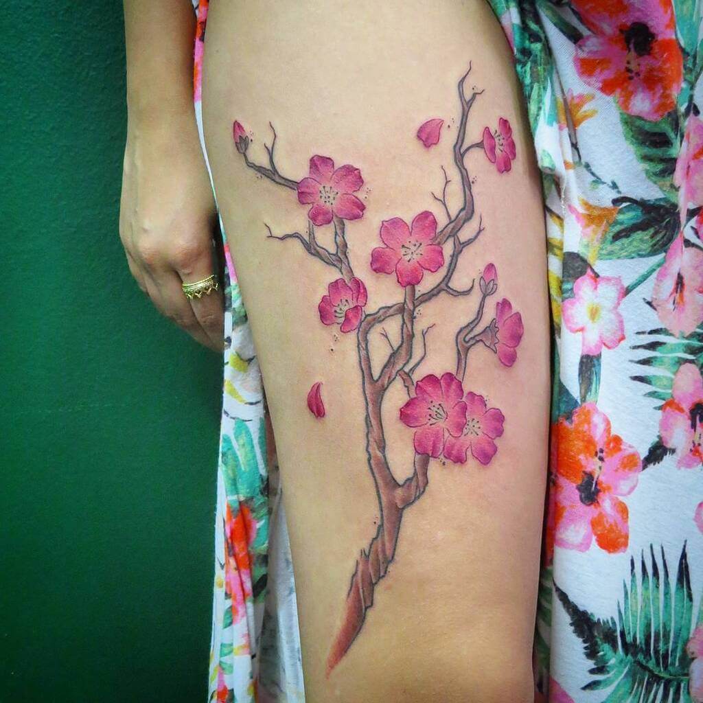 A woman's thigh with cherry blossom tattoos