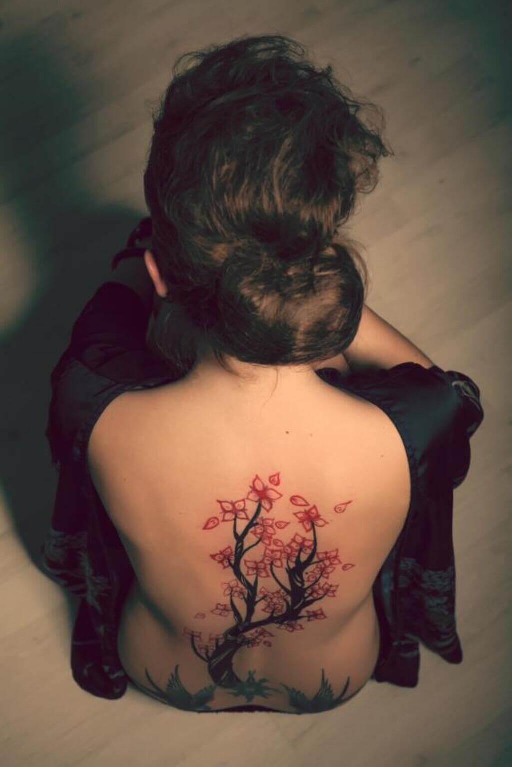 A woman wit cherry blossom tattoo on her back 