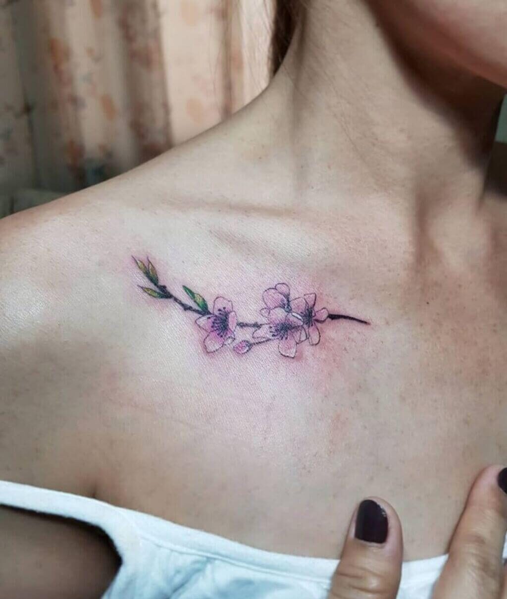 A woman with a  cherry blossom flower 
tattoo  on her chest 