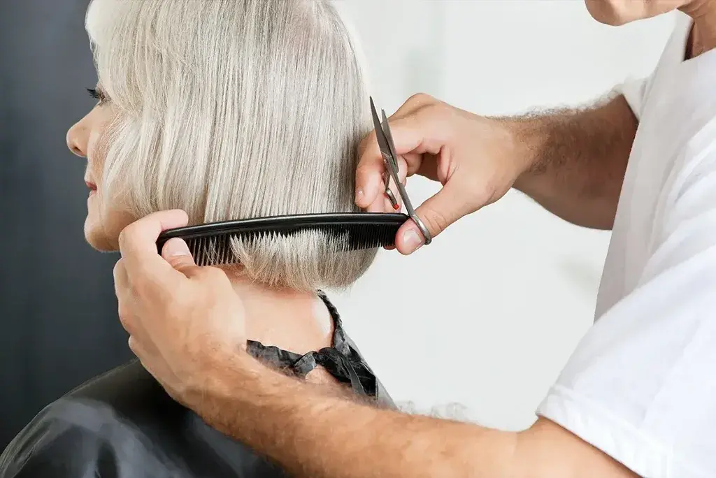 A man cutting a woman's hair