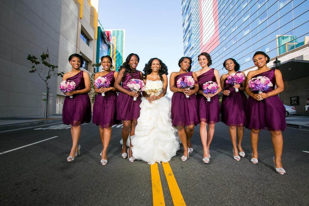A bride and her bridesmaids in purple dresses
